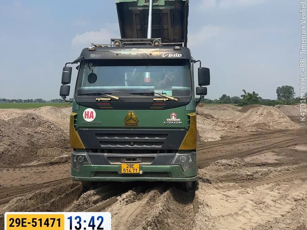 Xe ben đang đổ cát san lấp tại công trường